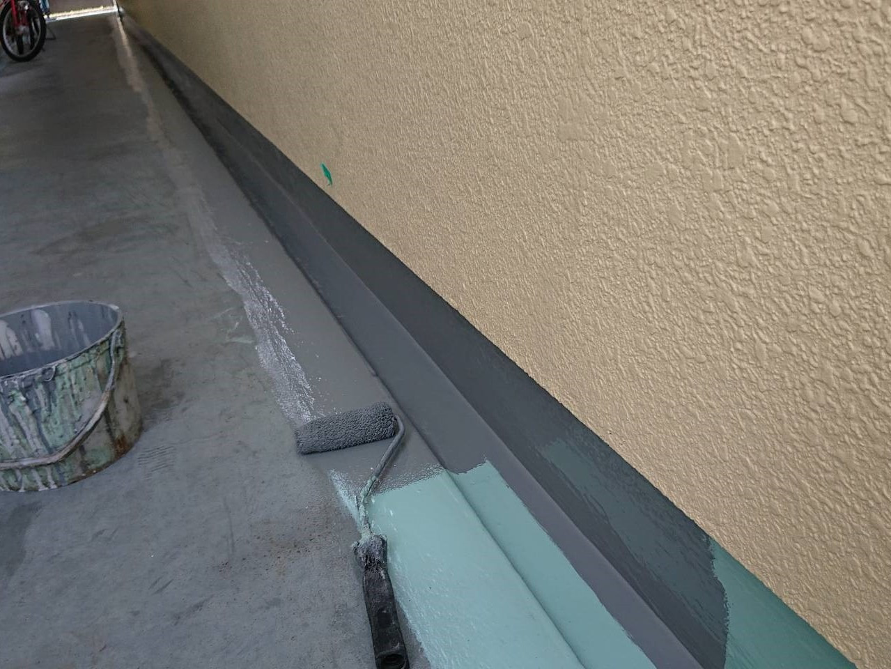 相模原市のM様邸集合住宅で外壁塗装・屋上防水工事の共用部床側溝ウレタントップコート塗りです。